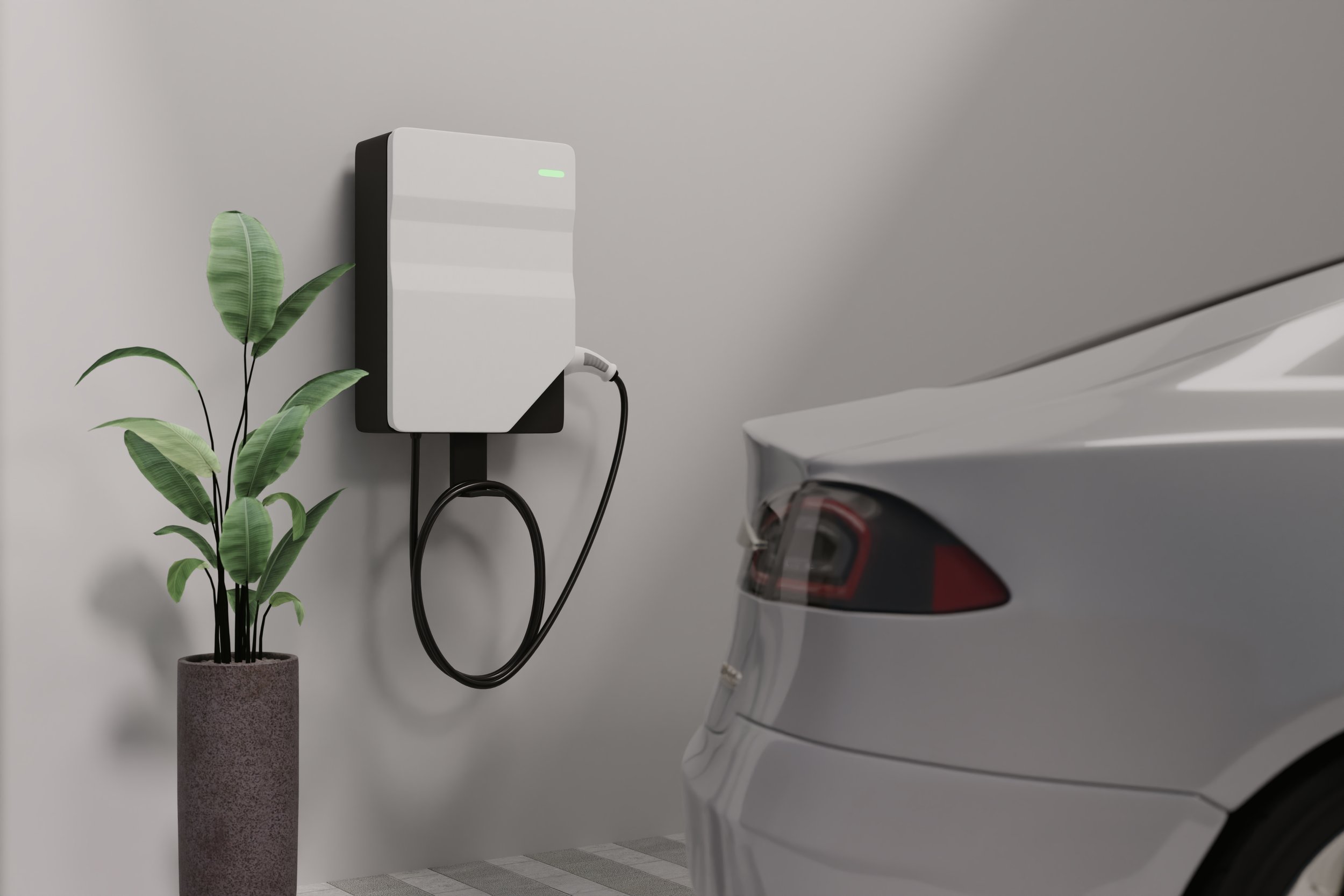 Electric car charging station with a cord plugged into a white electric car, next to a potted plant against a plain wall.