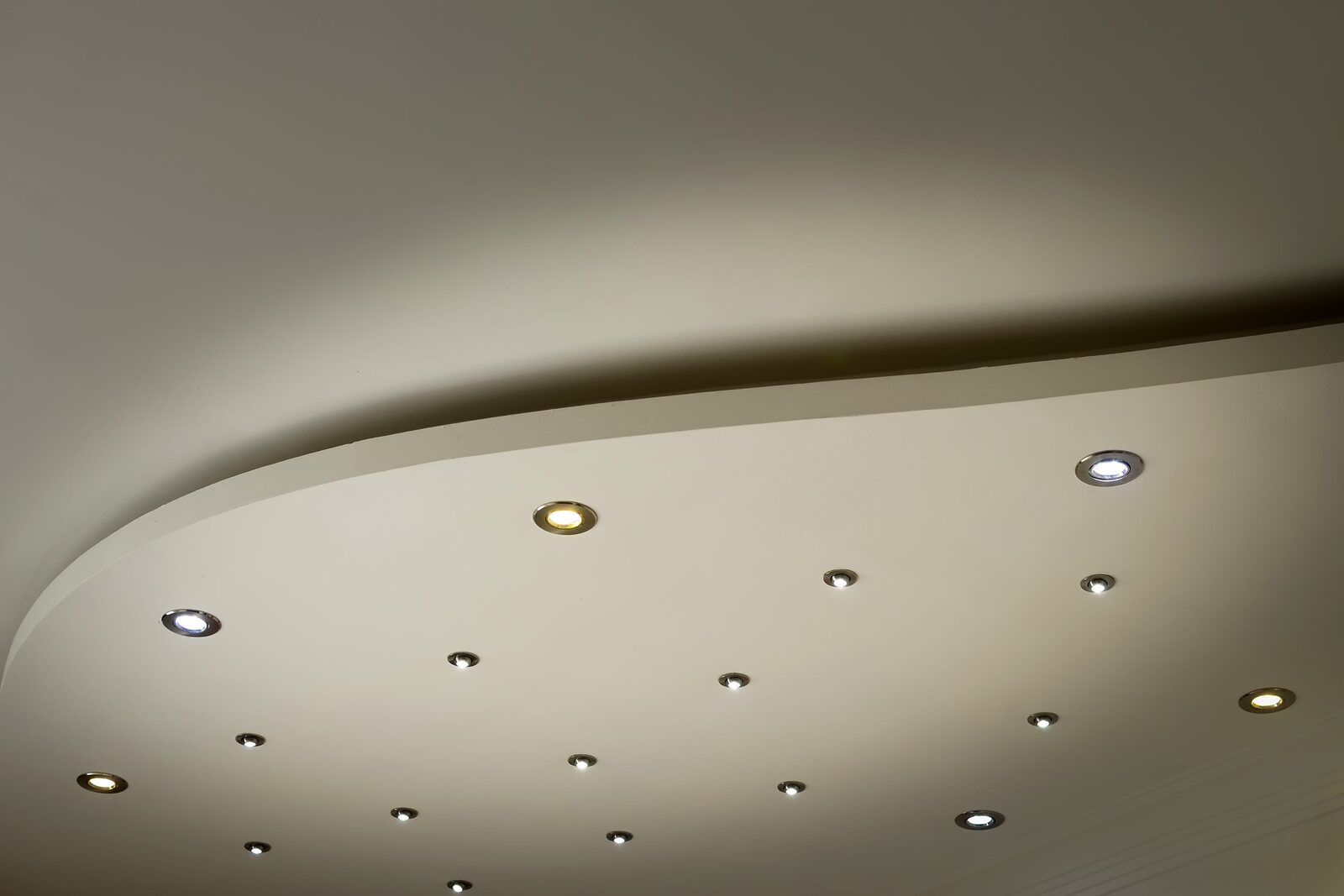 Ceiling with multiple recessed lights, some turned on and some off, in a modern room.